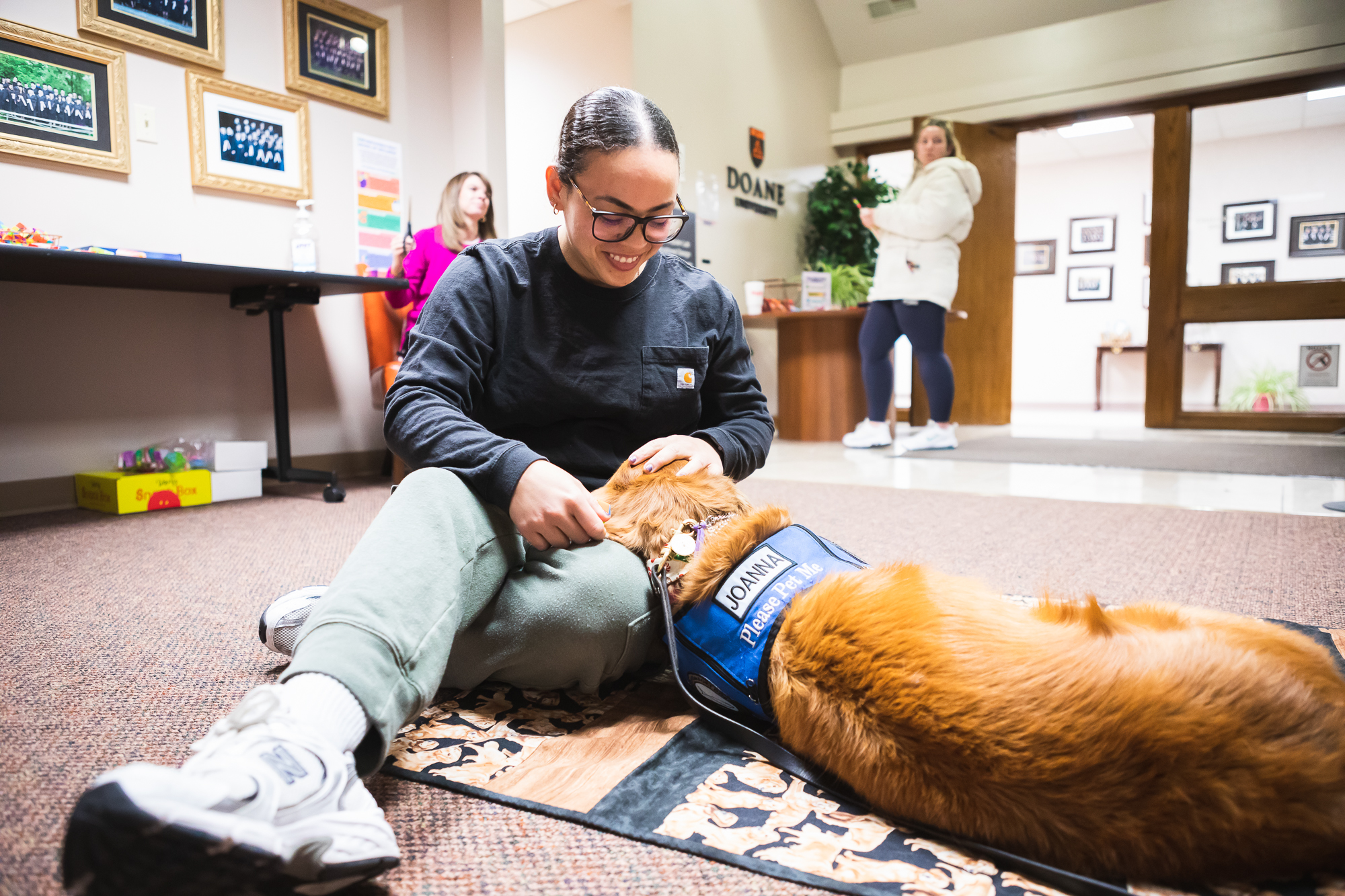 Master of Arts in Counseling student Ekianet Tamayo pets Joanna, a trained therapy dog, during a break between her classes in Lincoln.