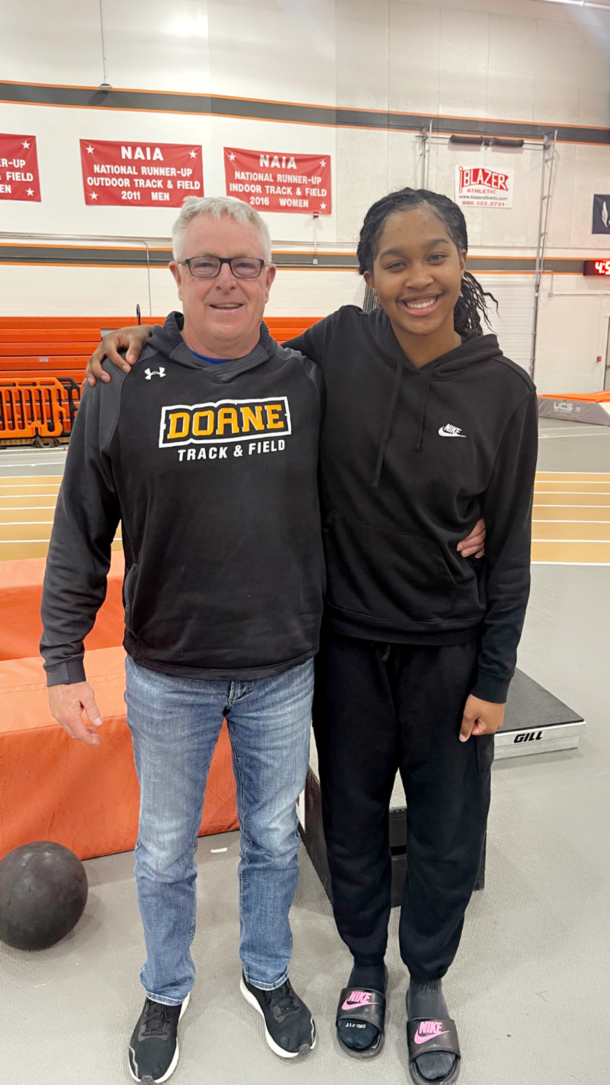 Head Track and Field Coach Ed Fye stands with student Jas Jackson ’24 inside Fuhrer Fieldhouse.