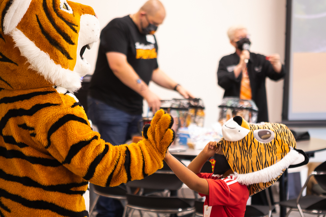 Thomas the Tiger giving high five to kid with tiger mask