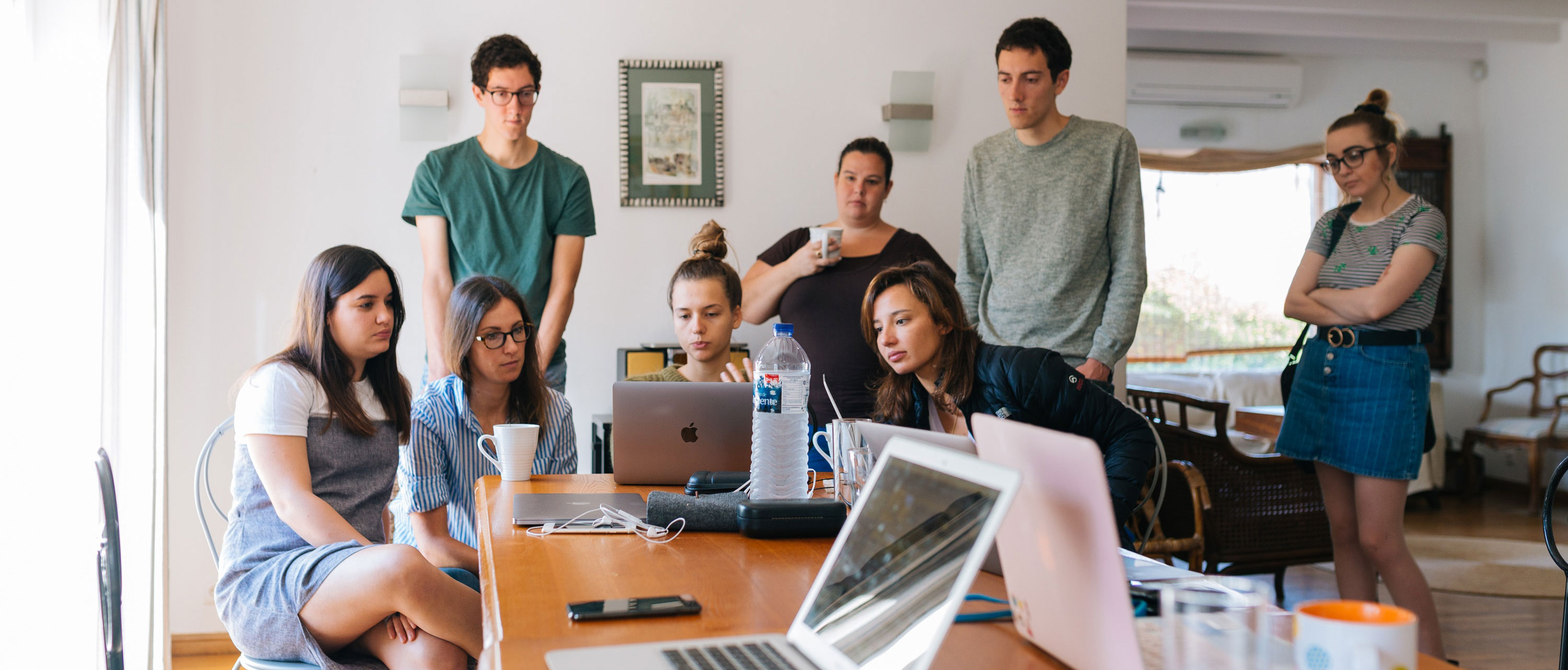 Group of people standing around a computer