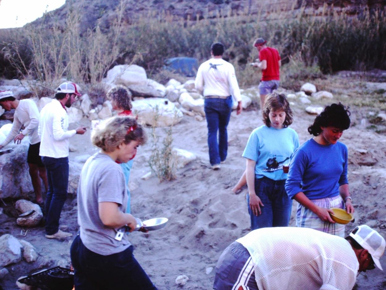 Students prepare or clean dinner dishes during a canoeing trip along the Rio Grande.