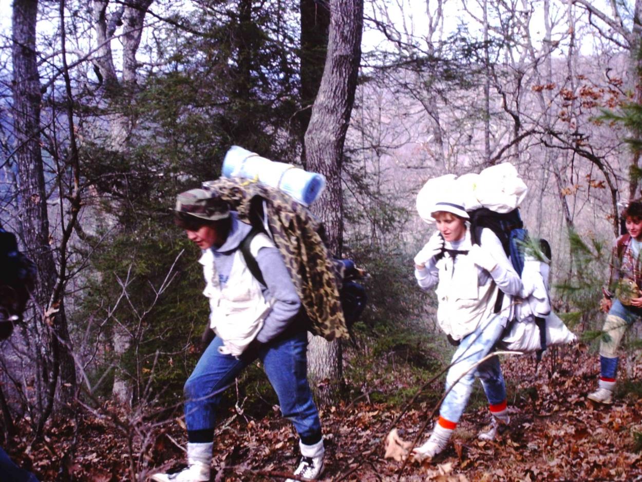 Students carrying large packs hike up a mountain during an interterm trip.