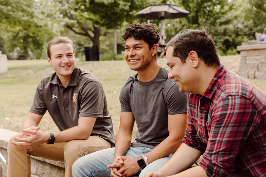 prospective students having a conversation on a bench