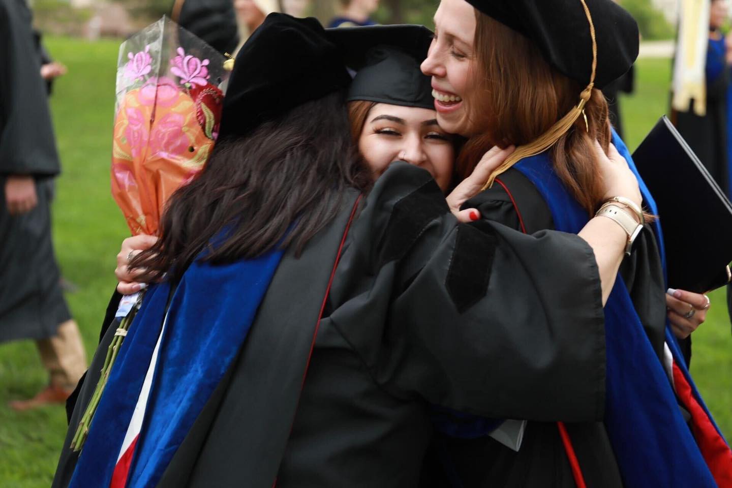 three graduating Doane students hugging.