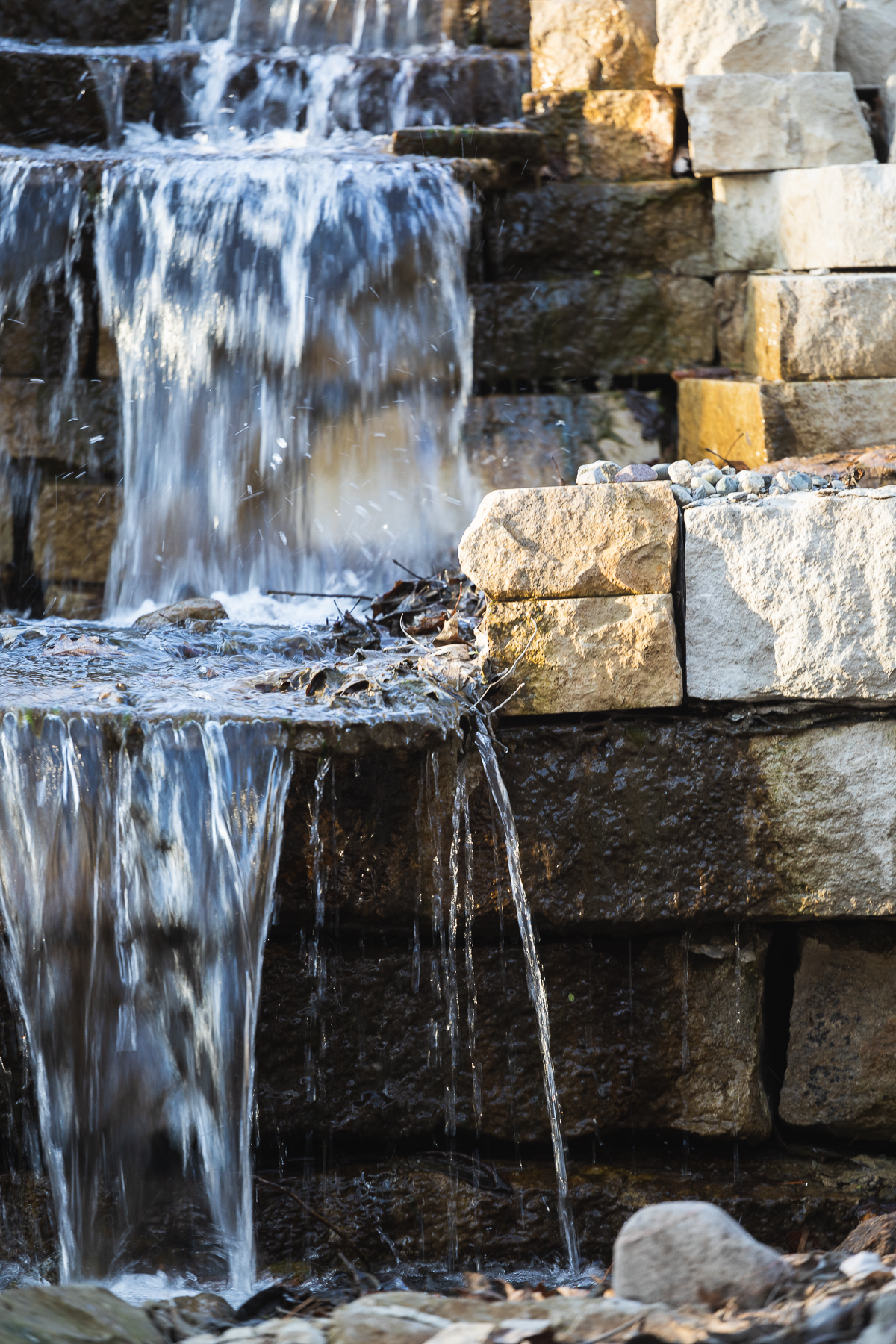 Water joyfully flows over steps made of rough-hewn, rectangular stone. 