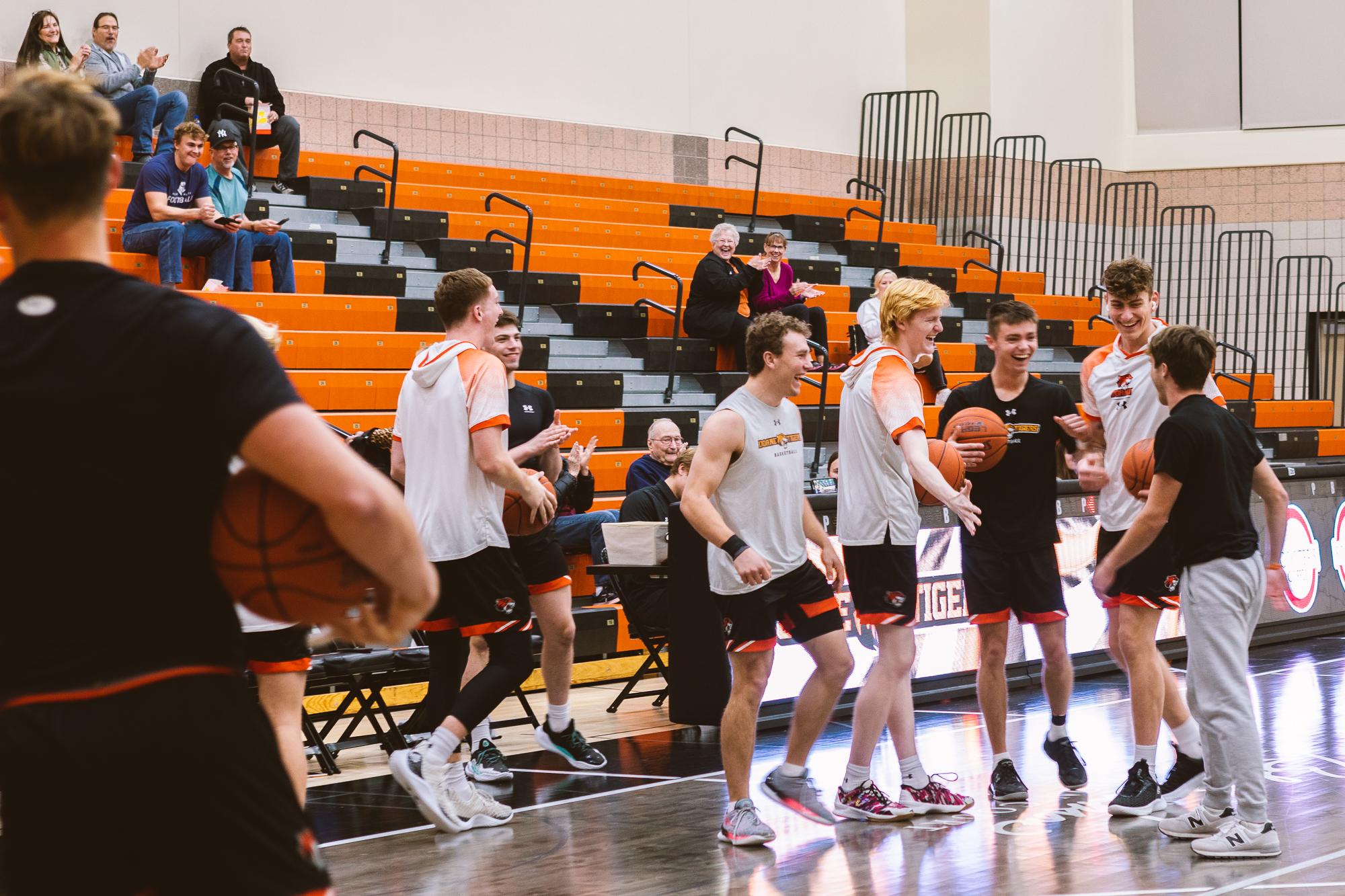 Members of the Doane men's basketball team congratulate a fellow student for making a half-court shot during a halftime challenge.