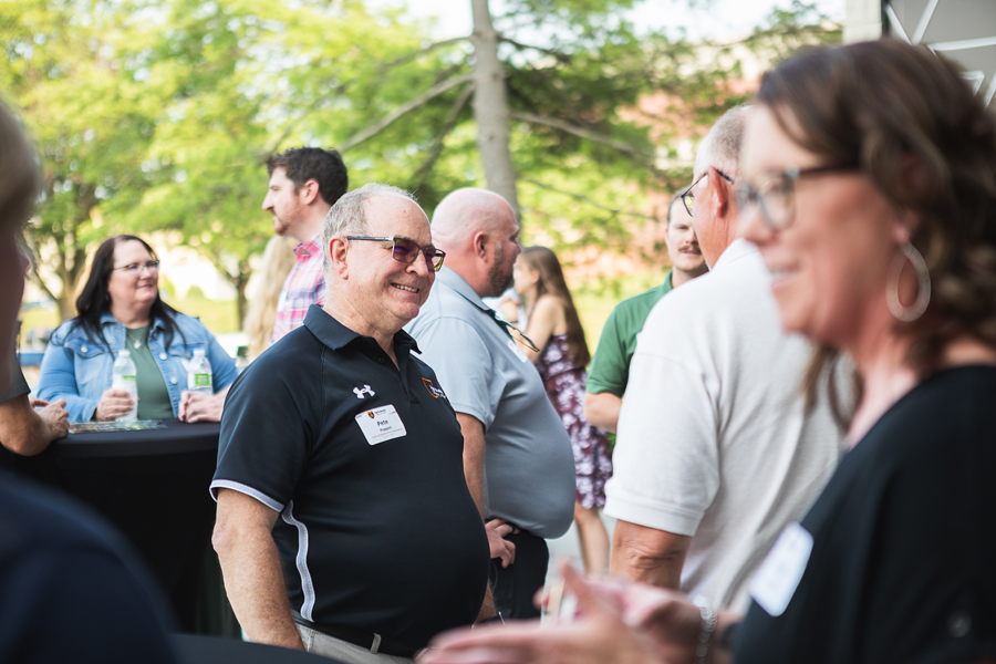 Pete Poppert, chair of the Agribusiness Department and assistant professor of practice in agribusiness, smiles during a conversation with attendees at networking and wine tasting event held by the department on Thursday, June 15.