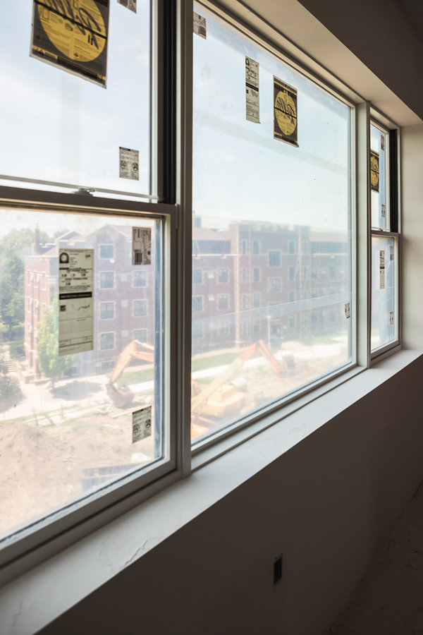 A window on the third floor of the residence hall overlooks construction equipment and Smith Hall. 