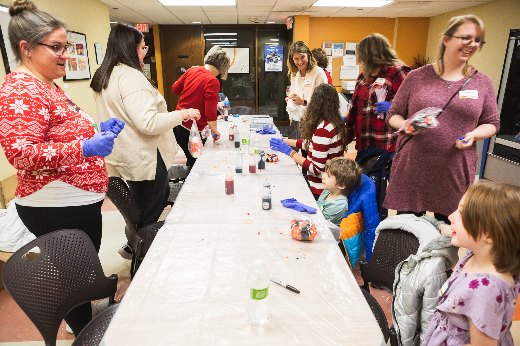 Doane staff and alumni, and their families, make orange and black tie-dye shirts during the Lincoln Holiday Open House on Friday, Dec. 1. 