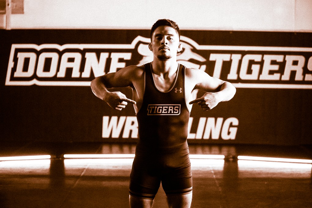 Senior Daniel Vargas points at the Tiger wrestling logo on his chest.