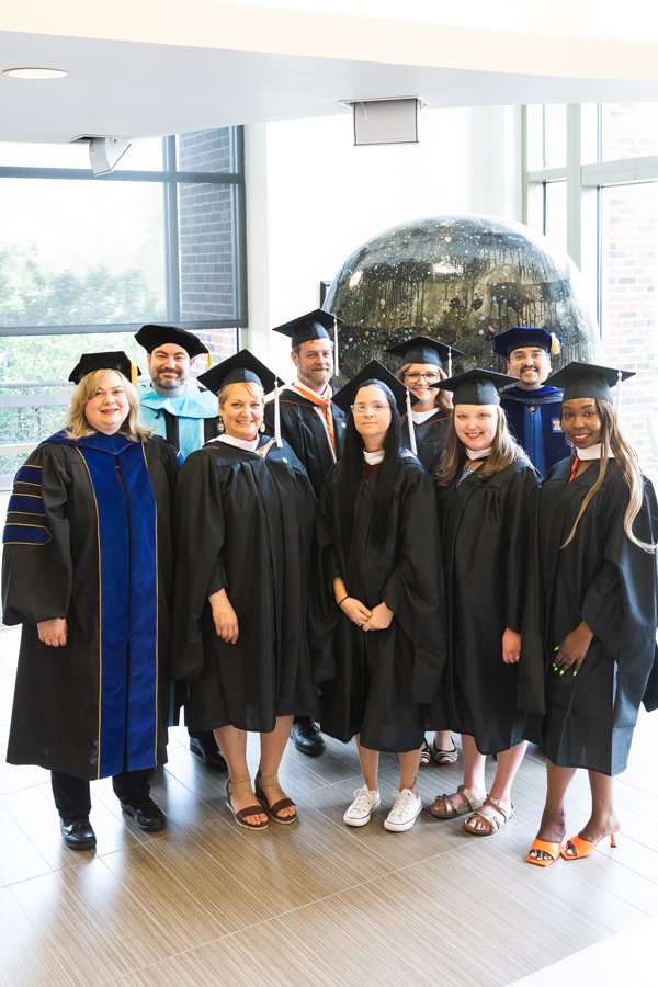 Graduates of the Master of Arts in Management and Master of Arts in Leadership programs pose with Dr. Jen Bossard (left), dean of the College of Business, and Dr. AJ Chauradia, assistant professor of business and chair of Doane's Business Department.