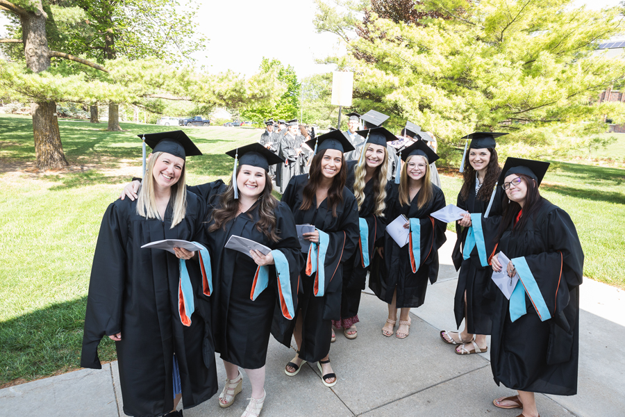 Graduates from Doane's Master of Education in School Counseling pose before lining up to walk into Cassel Theatre to receive their diplomas. 