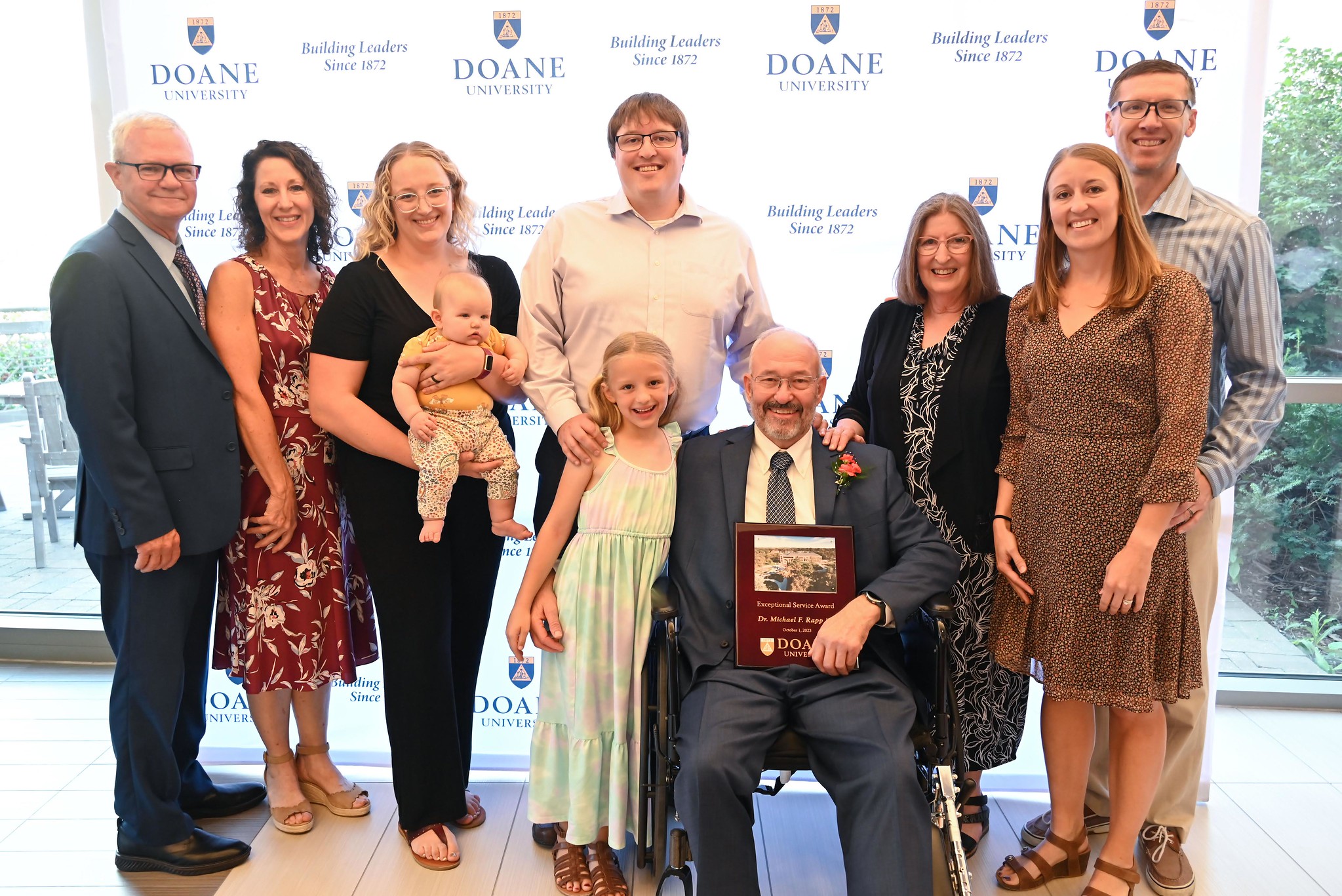 Dr. Michael Rapp holds his award plaque for a photo while surrounded by family. 
