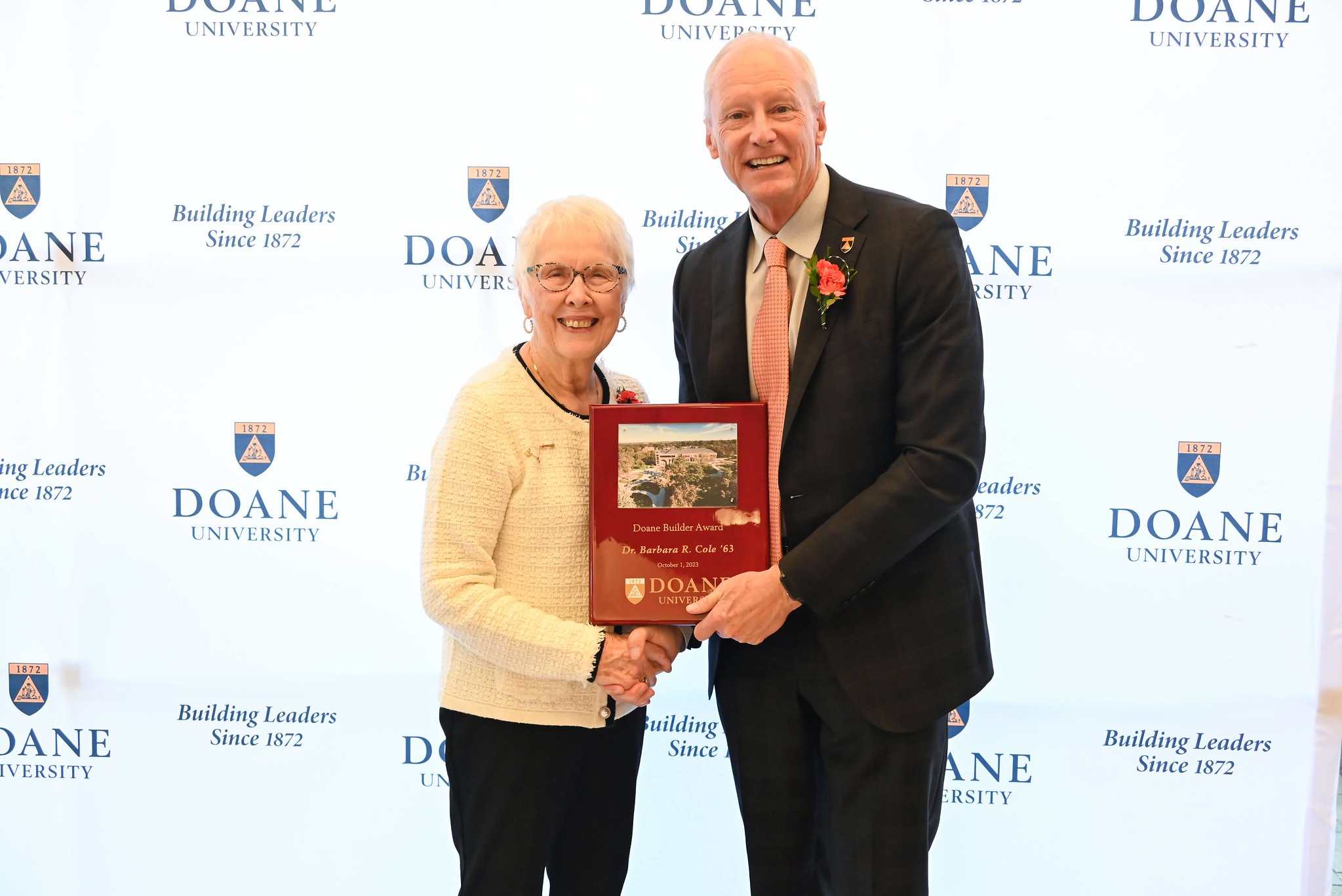 Dr. Barbara Cole shakes the hand of Dr. Roger Hughes. 