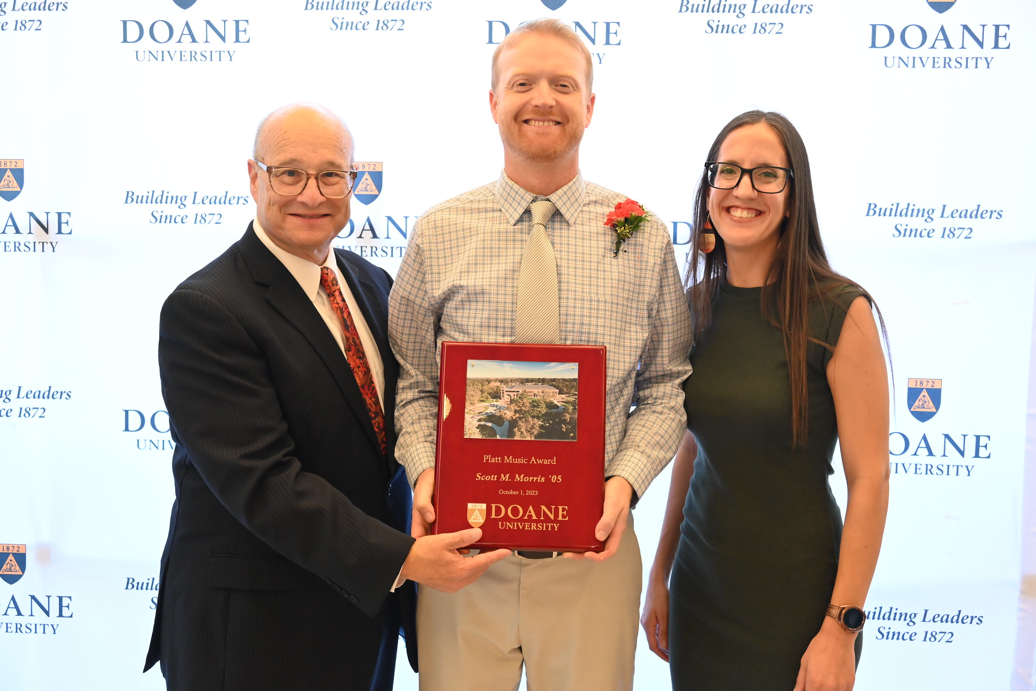 Scott Morris and his spouse stand next to Dr. Jay Gilbert, former director of bands at Doane University.