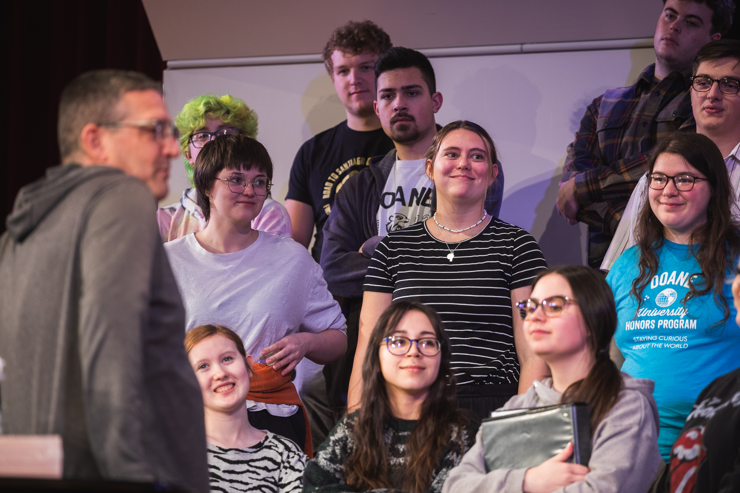 Choir students stand on the risers in between singing