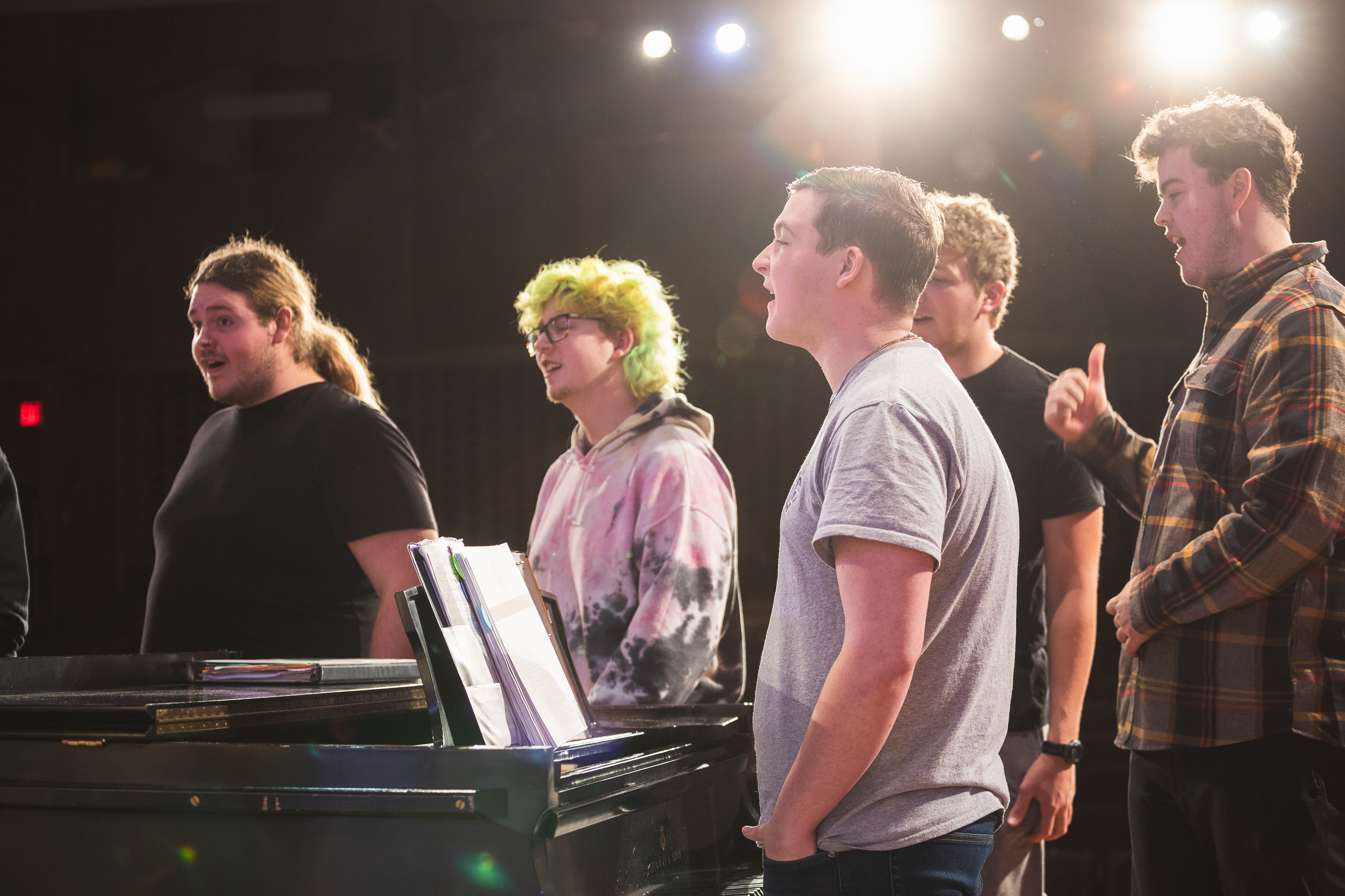 Students rehearse around a piano