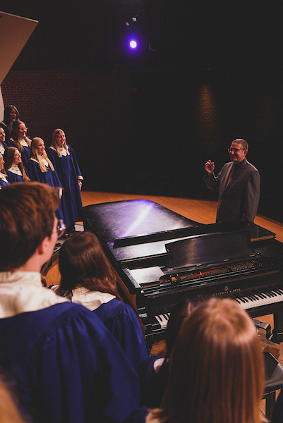 Kurt Runestad directs the choir on stage