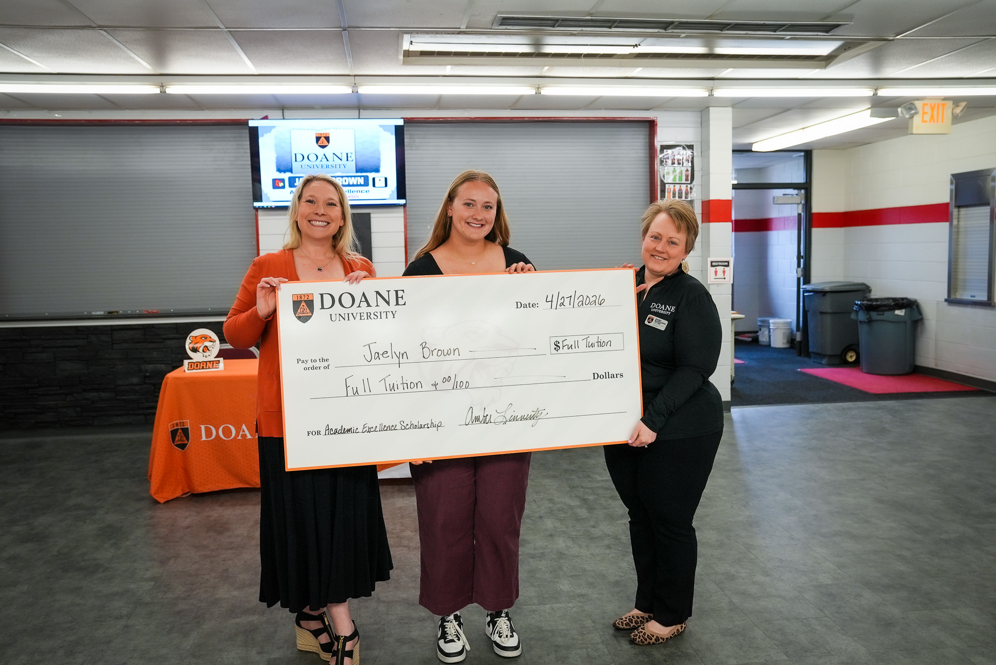 Jaelyn Brown holding a check for her Academic Excellence Scholarship