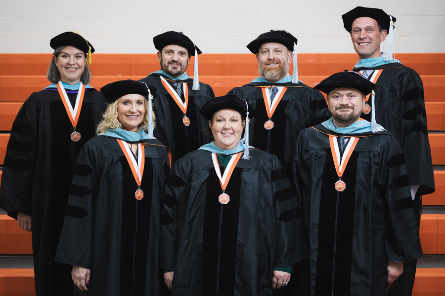 Six graduates of Doane's Doctor of Education program stand with Dr. Cate Sommervold, director of the program (top far left.)