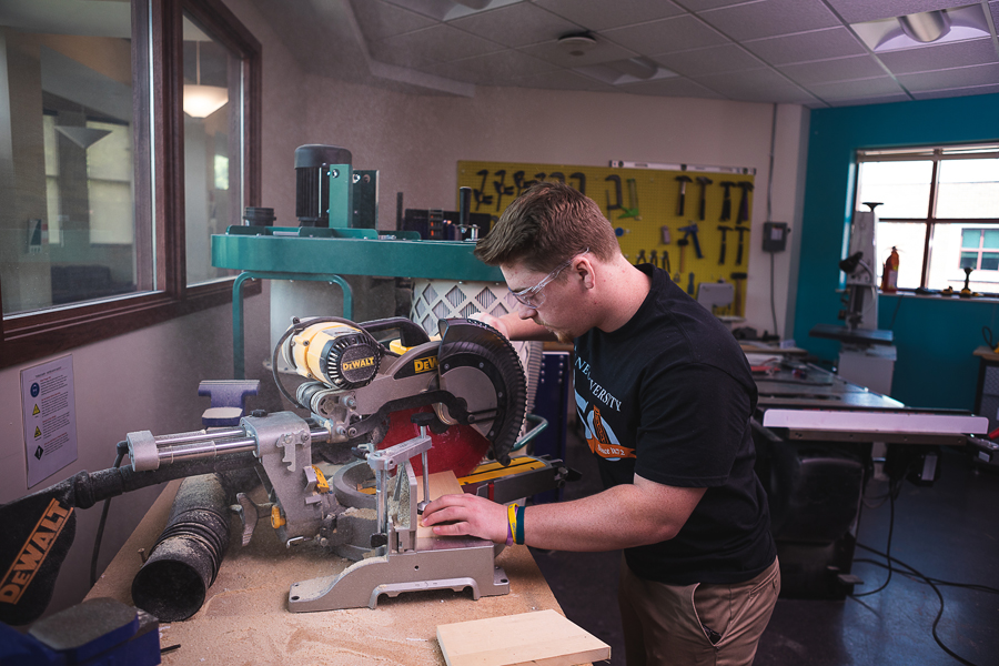 Jeremey Allgeyer, a junior completing his degree in Doane University’s Bachelor of Science in Engineering program, uses a circular saw to trim a piece of wood in the engineering and physics department’s lab.
