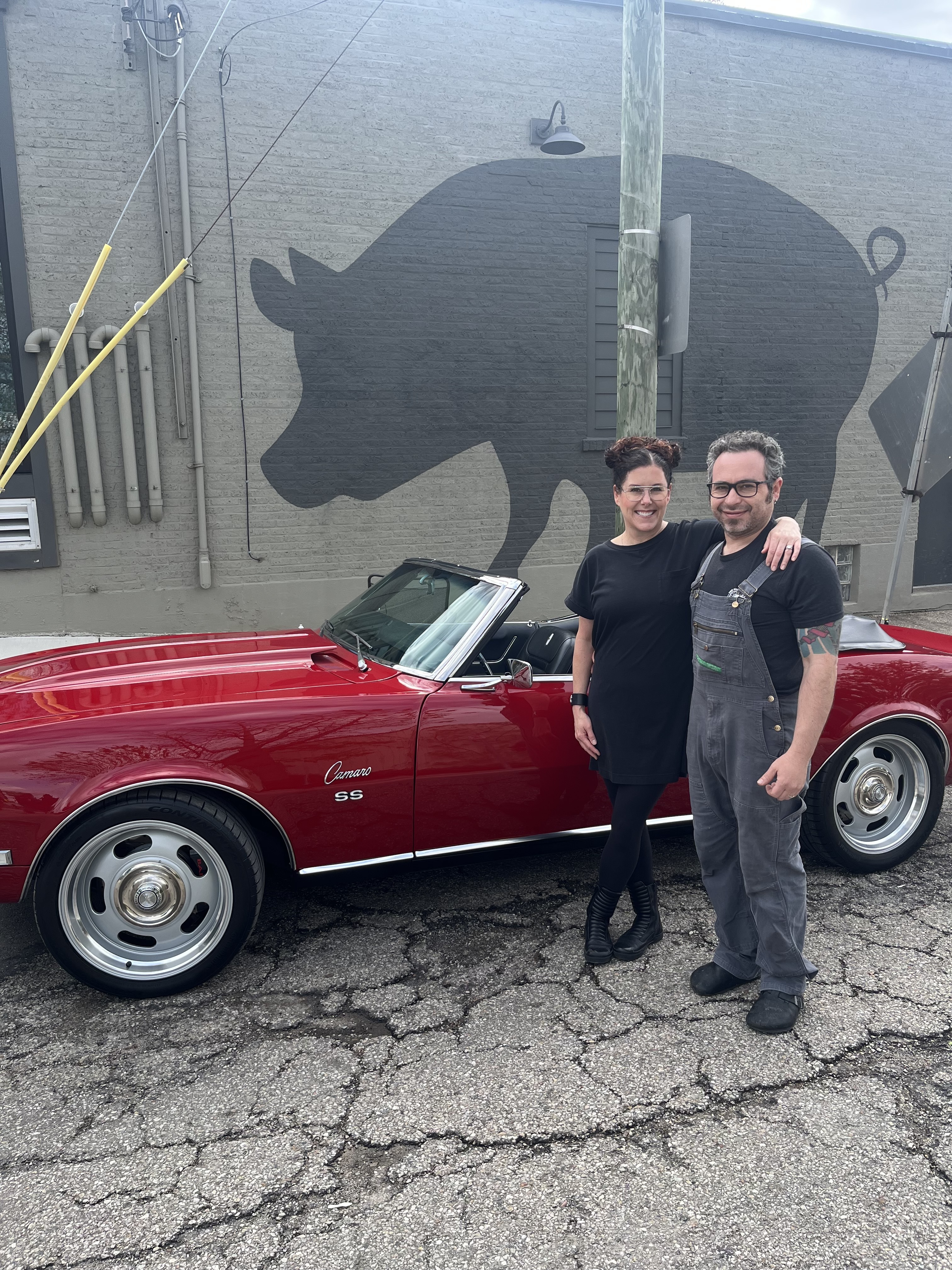 Libby and Gary stand in front of Guy Fieri's car