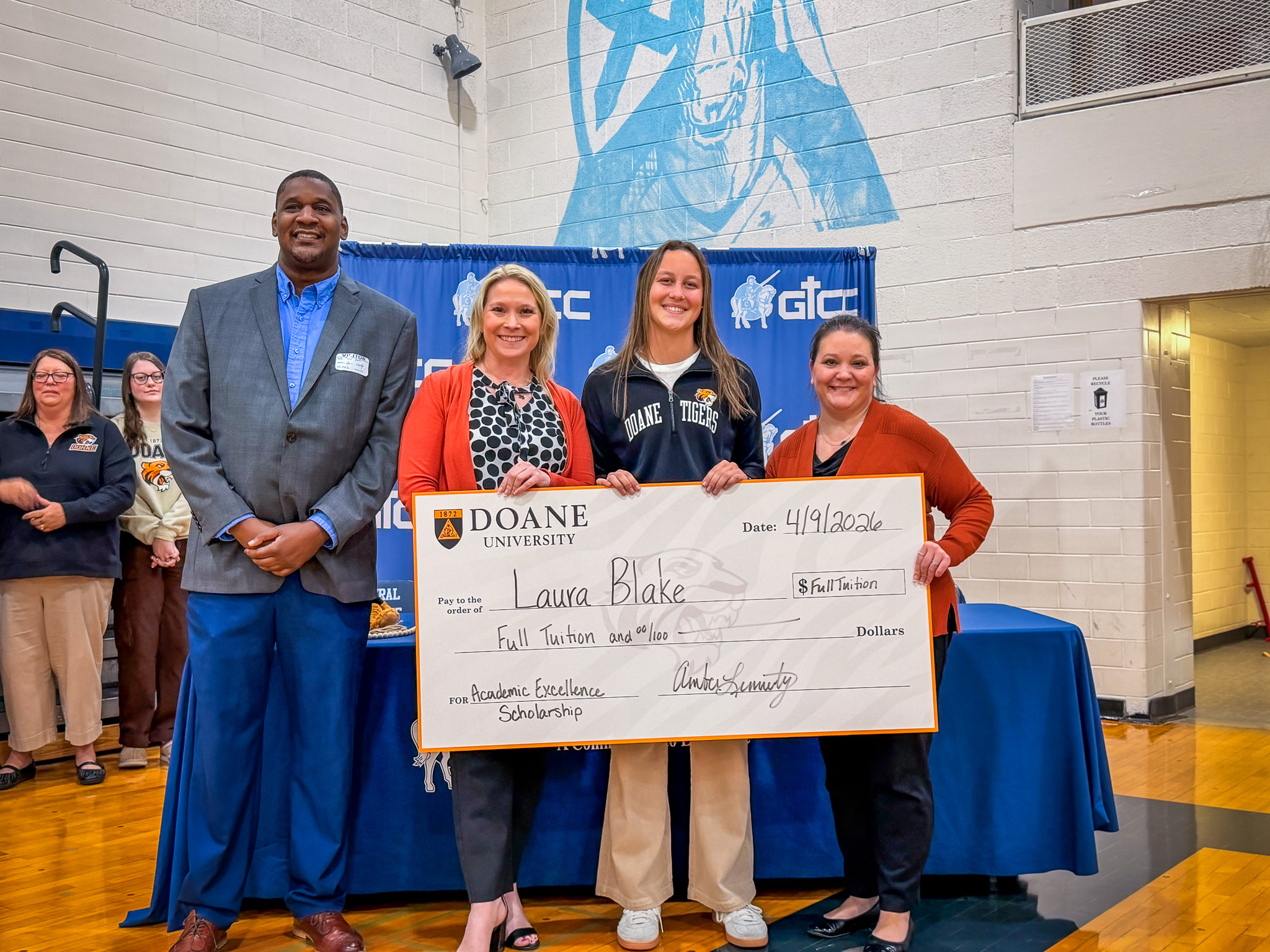 Laura Blake holding a check for the Academic Excellence Scholarship