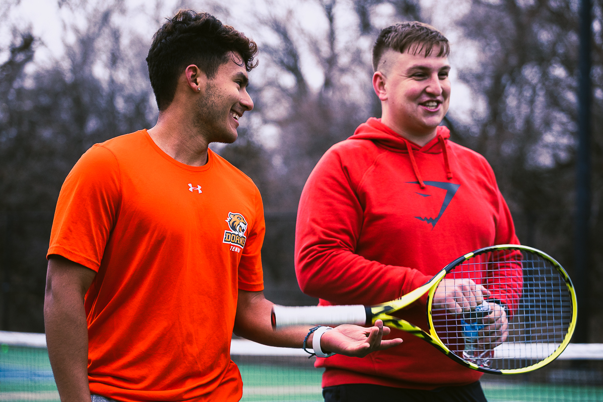 Jorge Chevez stands on the court with one of his tennis teammates