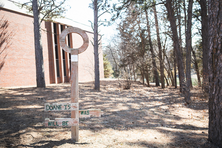 Image of a sculpture on Doane's campus shaped like a key. The key reads "Doane is, was, will be" on its teeth. 
