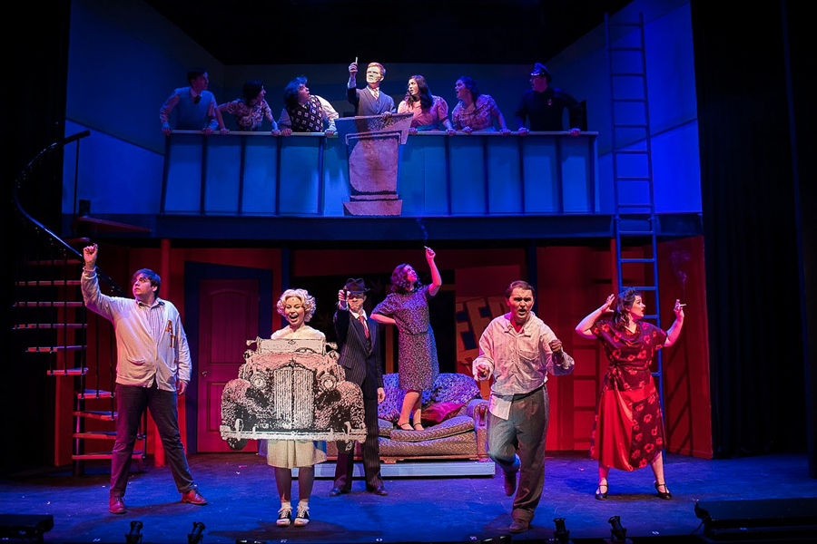 The cast of Doane's 2022 production of "Reefer Madness" stand on two levels of the set, lit with red and blue lights.  