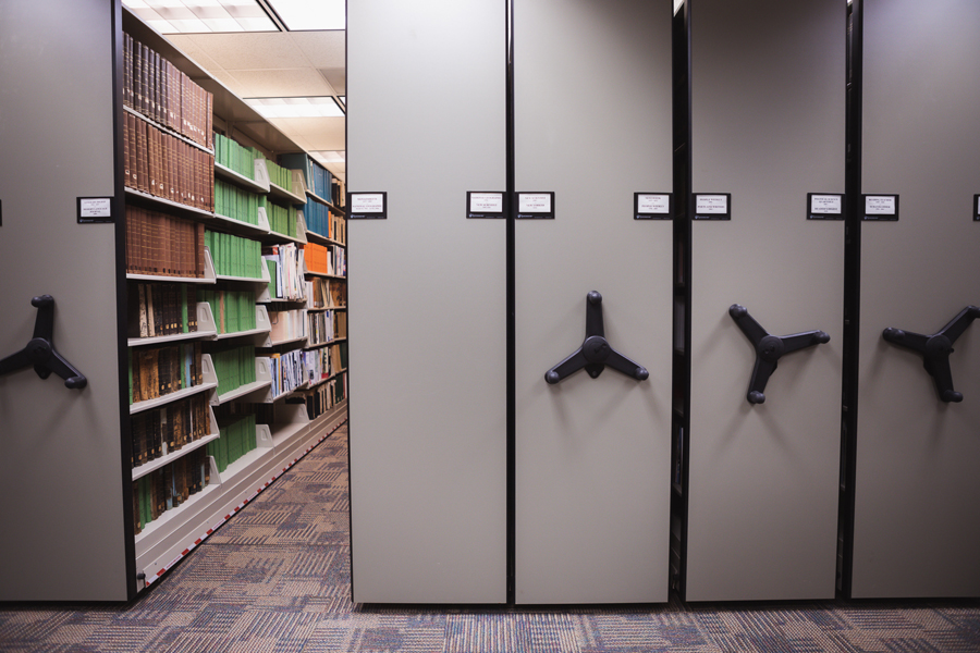 Image of the moveable stacks in the lower level of Perkins Library. The stacks can be moved to view journals and magazines by turning a wheel.
