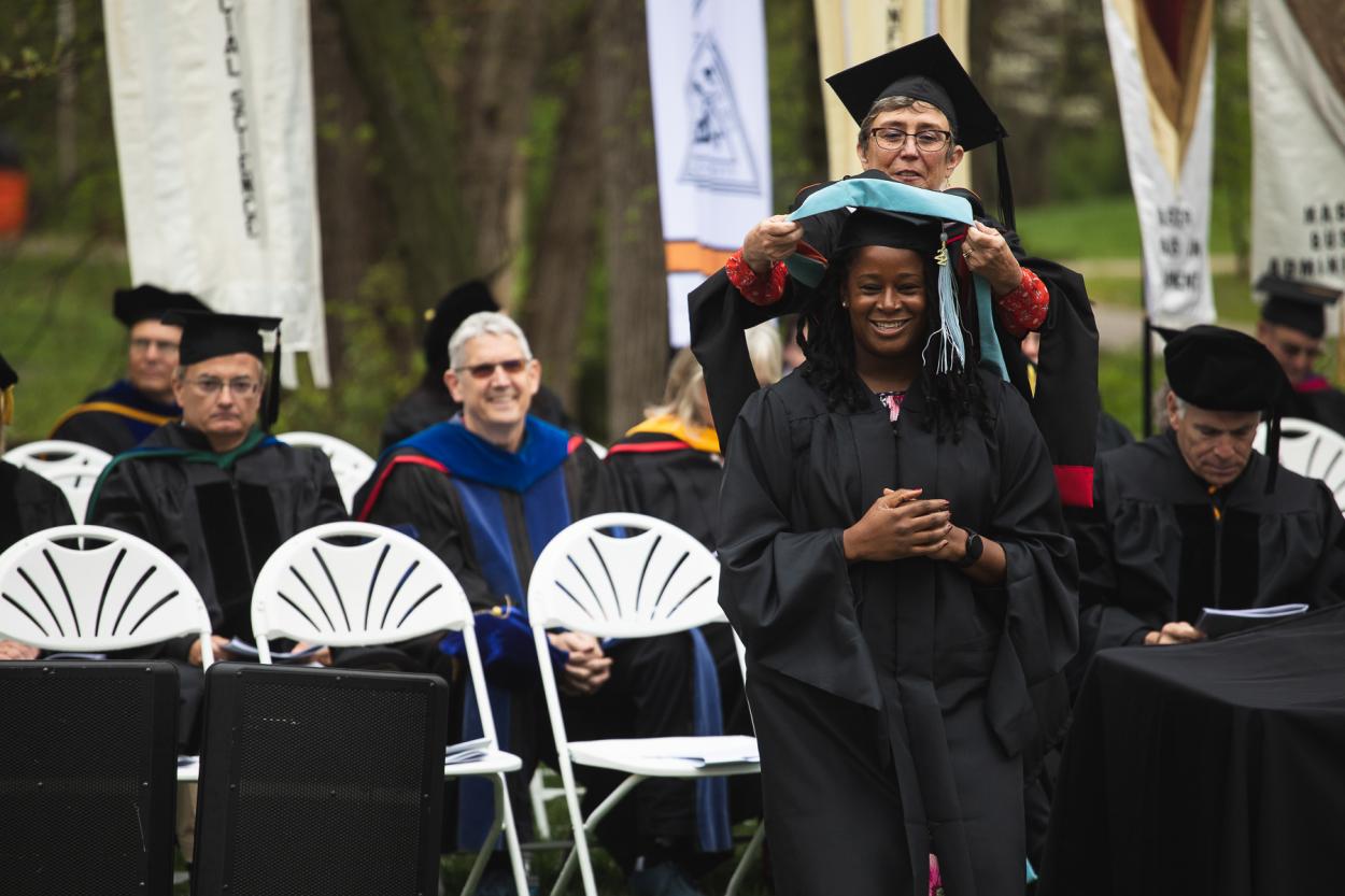Charity Iromuanya '22E is hooded by Jodie Green, her advisor and the director of Doane's Master of Education in School Counseling program.