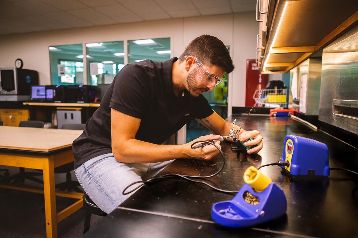 Henrique Henriques ’23, a senior completing his degree in Doane University’s Bachelor of Science in Engineering program, fixes up the solder on a radio antenna used as part of a summer research project.