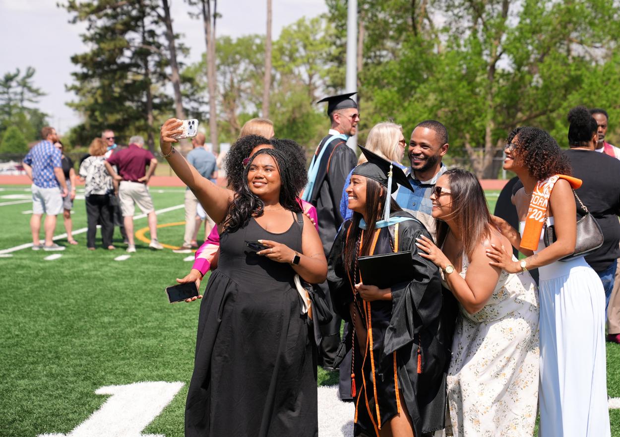 Student poses with family for a selfie at Doane University's 2026 spring commencement