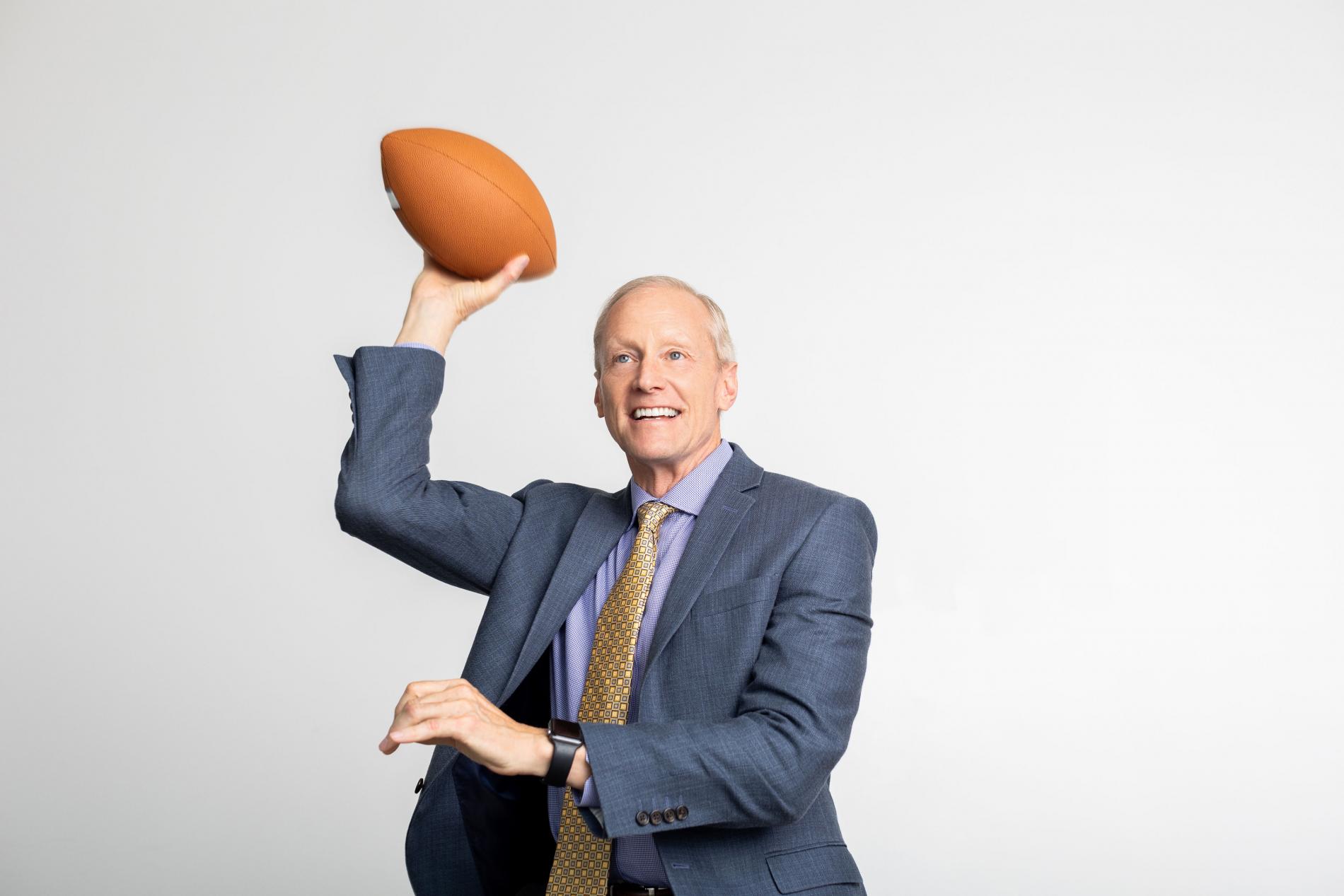 Dr. Roger Hughes holds a pose like he's about to throw a football.