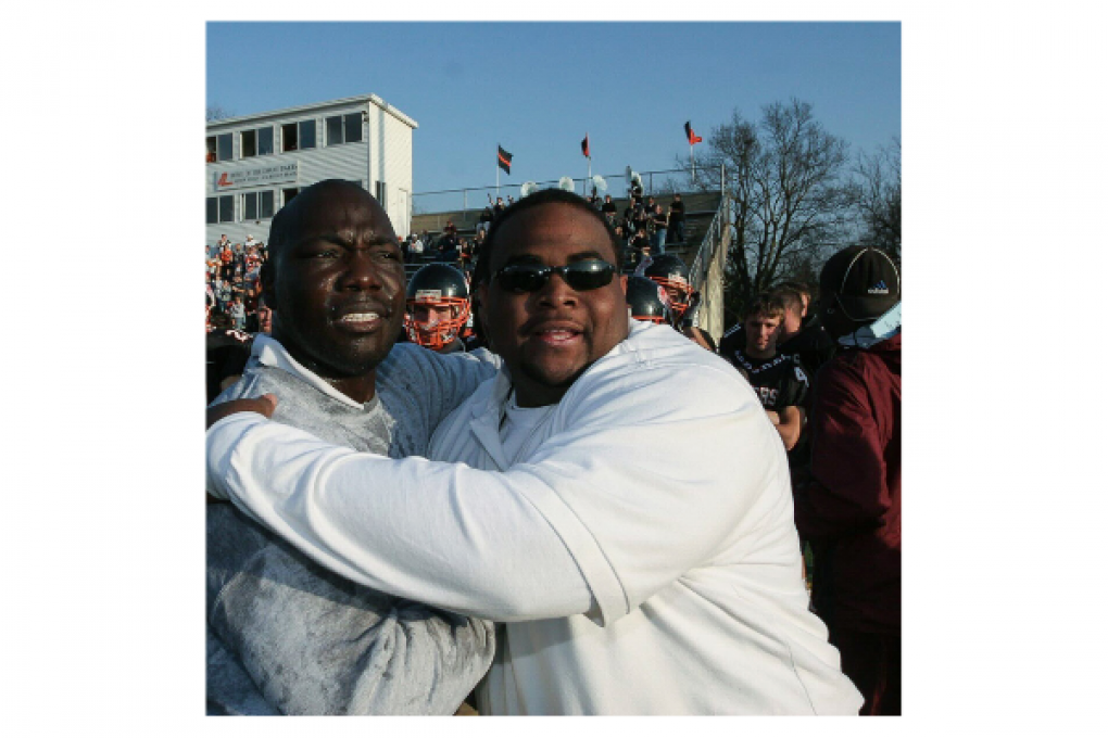 Brad Davis (right) hugs Tommie Frazier (left) inside Doane's Memorial Stadium.
