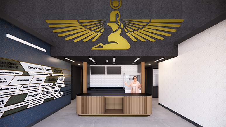 Architectural rendering of the lobby of the revitalized Isis Theatre in Crete, Nebraska. A golden representation of the ancient Egyptian goddess Isis is prominently featured on the wall above a bronze art deco sales and concessions counter. A blue wall with a gold art deco motif to the left displays the names of donors and a wall on the right is painted white with the same gold art deco motif. Doors on either side of the wall behind the counter lead to the theater and other amenities. 
