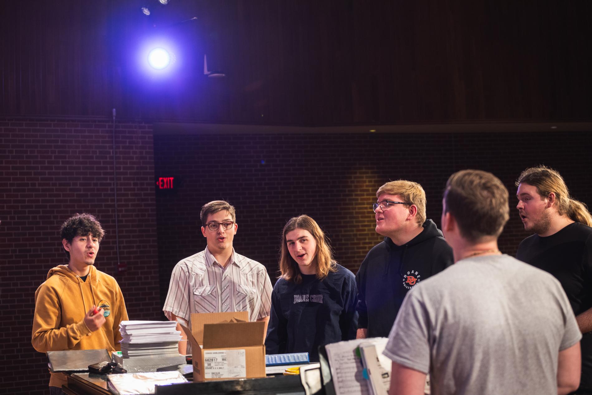 Students rehearse around a piano