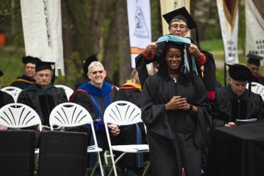 Charity Iromuanya '22E is hooded by her advisor and the director of  Doane’s Master of Education School Counseling program, Jodie Green.