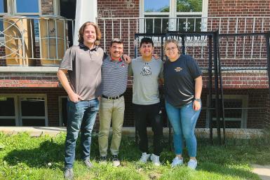 Nina Theiler '19 (right) stands next to Tigers on Tour Riley Reyes ‘24, Robb Foote ‘24 and Justin Nevells ‘24 in front of the Quads as they move bed frames for donation. 