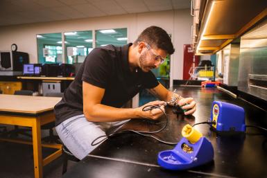 Henrique Henriques ’23, a senior completing his degree in Doane University’s Bachelor of Science in Engineering program, fixes up the solder on a radio antenna used as part of a summer research project.